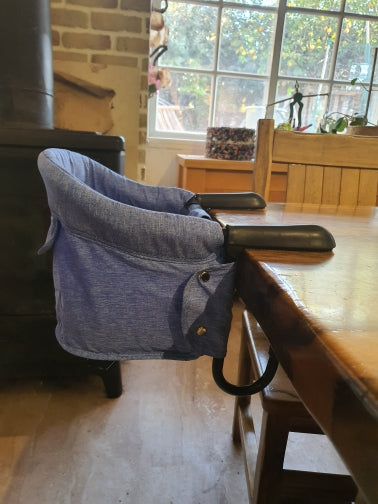 Blue baby Foldable Seat on a wooden table 