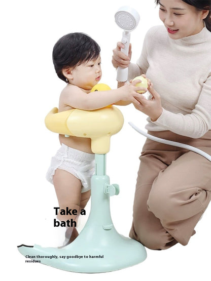 A baby using a yellow bath seat with a woman holding a shower head, on a white background.