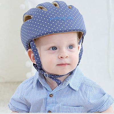 Baby wearing navy polka dot toddler safety helmet