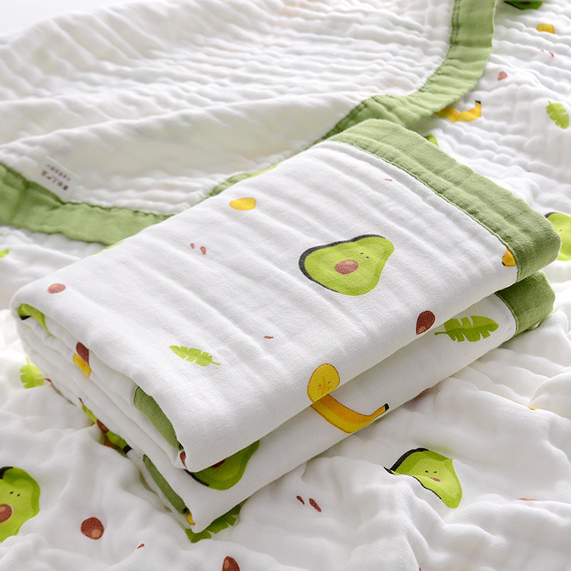  Folded 6-layer muslin cotton swaddle blanket with green trim and dinosaur print, laid on a matching muslin blanket