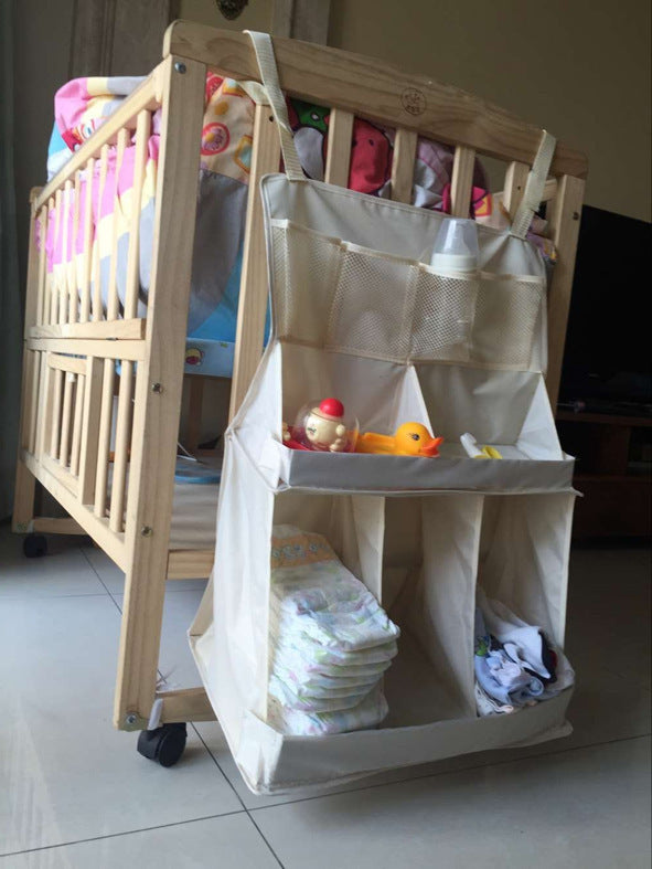 Hanging nursery organizer attached to the side of a wooden baby crib