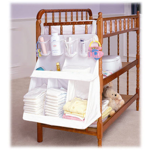 White hanging crib organizer with pockets holding diapers, wipes, and baby essentials
