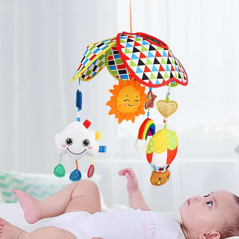 Musical crib toy hanging above baby on bed
